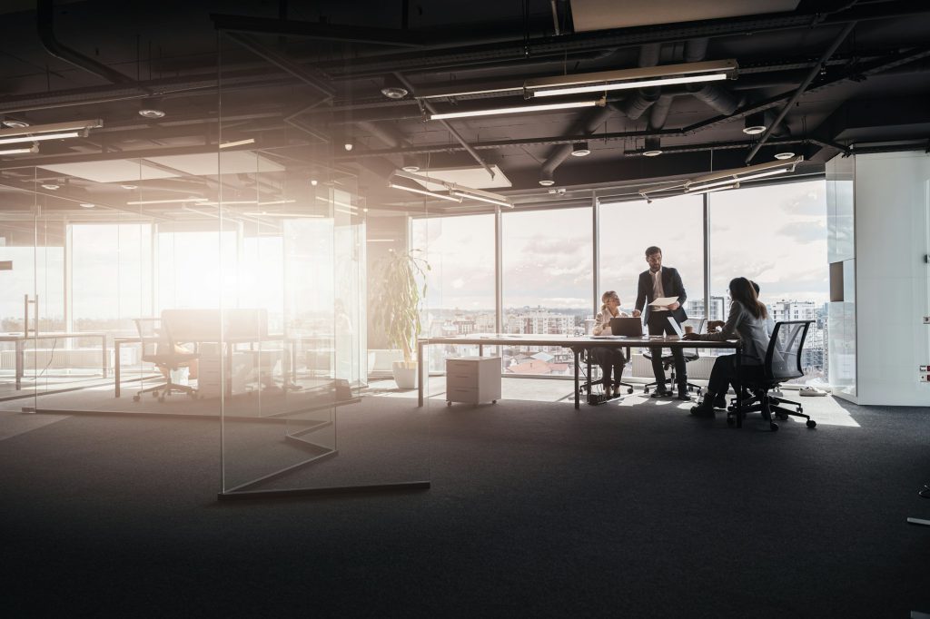 Team of young businessmen working and communicating together in office, people standing near table